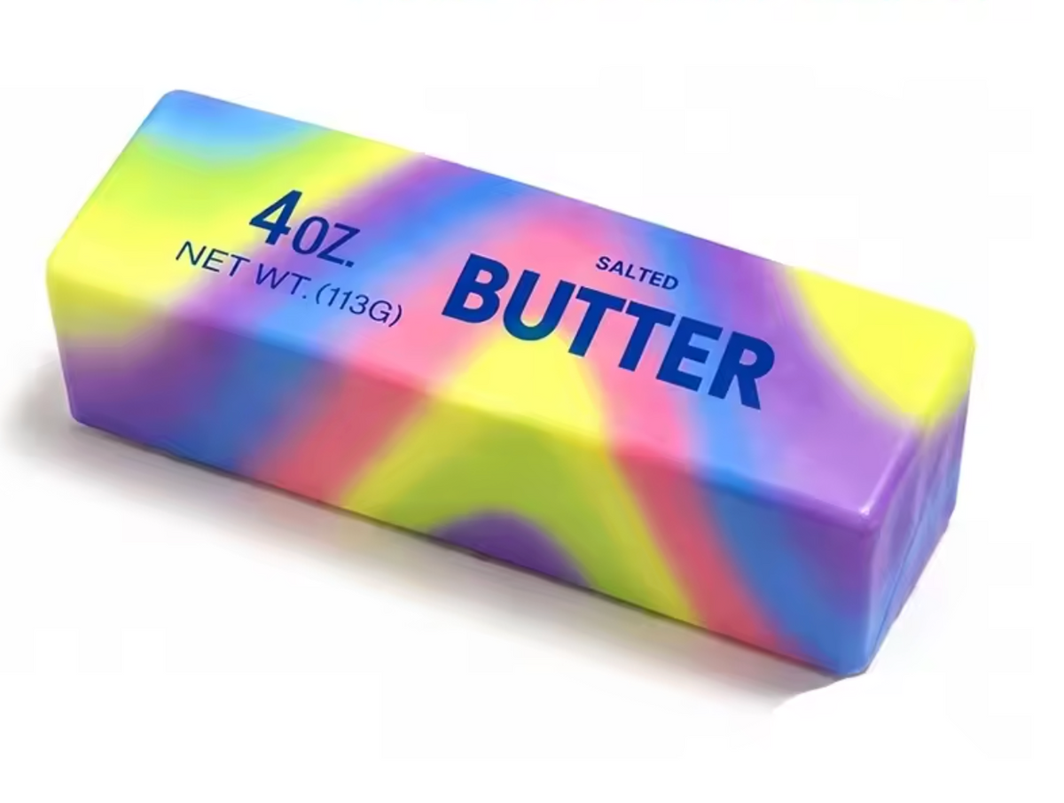 A 4 oz stick of salted butter with a vibrant rainbow tie-dye pattern in yellow, green, blue, purple, and pink, on a clean white background.